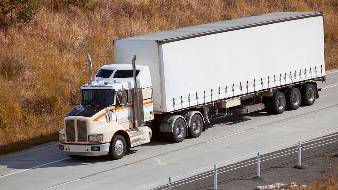 An 18 wheel truck on a road.
