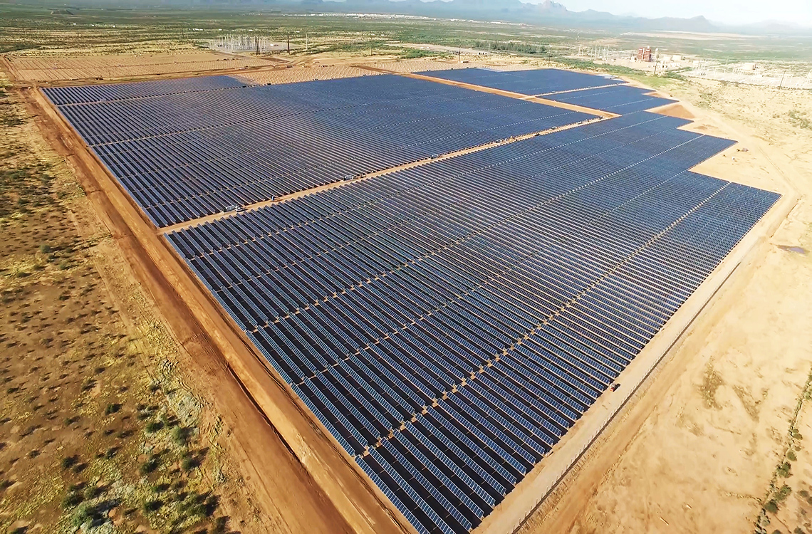 The image shows a solar power field in Morocco. There are many rows of solar panels.