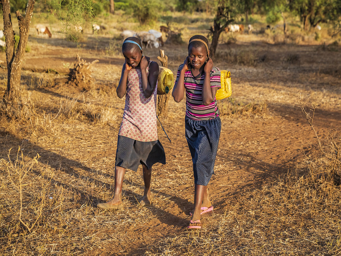 A child collecting water from a pipe in Kenya, East Africa.
