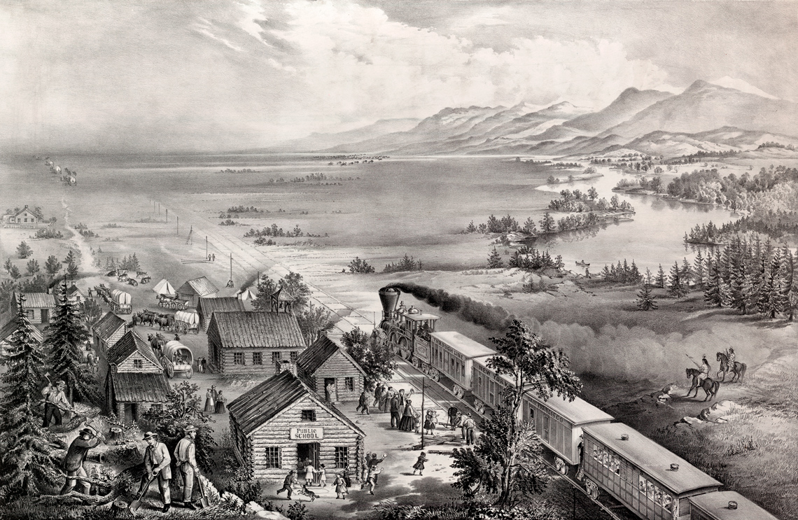 A small rural settlement with a train going through the town.