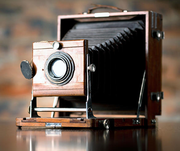 This is an antique camera. It has a lens which attaches to an accordion that attaches to a box.