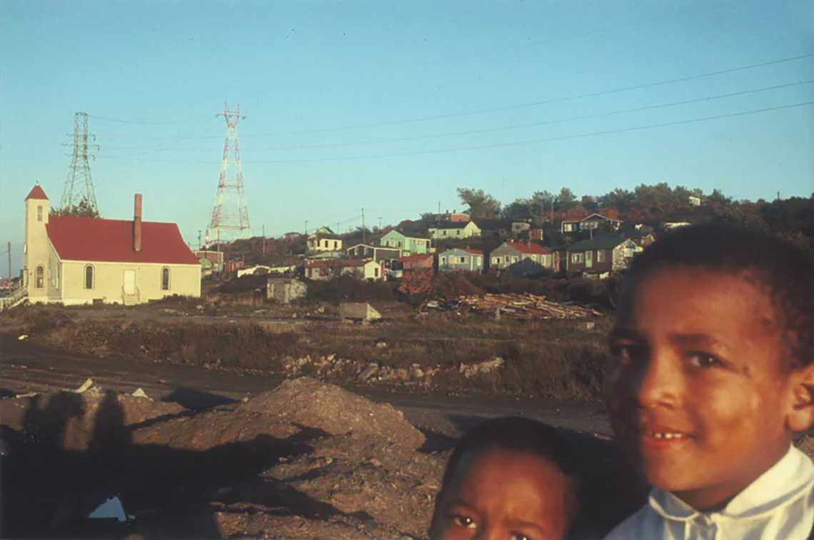 Two children in Africville with the Seaview United Baptist Church behind them