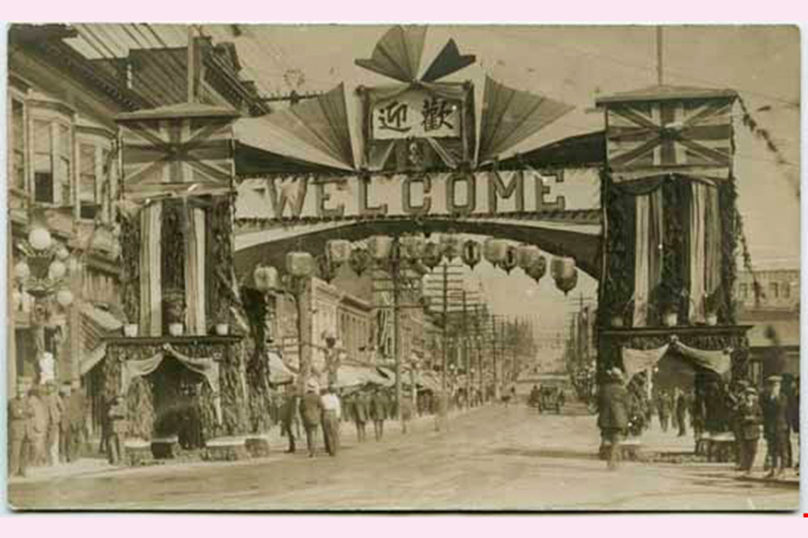 An old photograph of a Chinese street arch at Carrall and Pender streets with the words “Welcome” seen on the arch