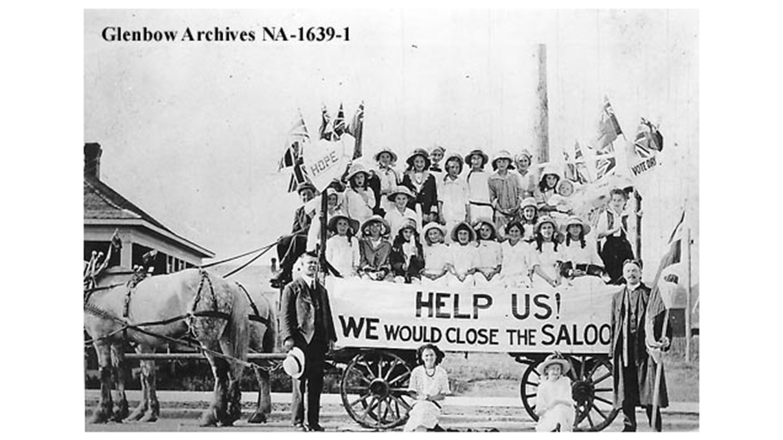 Women and girls on a carriage, holding a sign that reads, “Help Us! We would close the Saloon.”