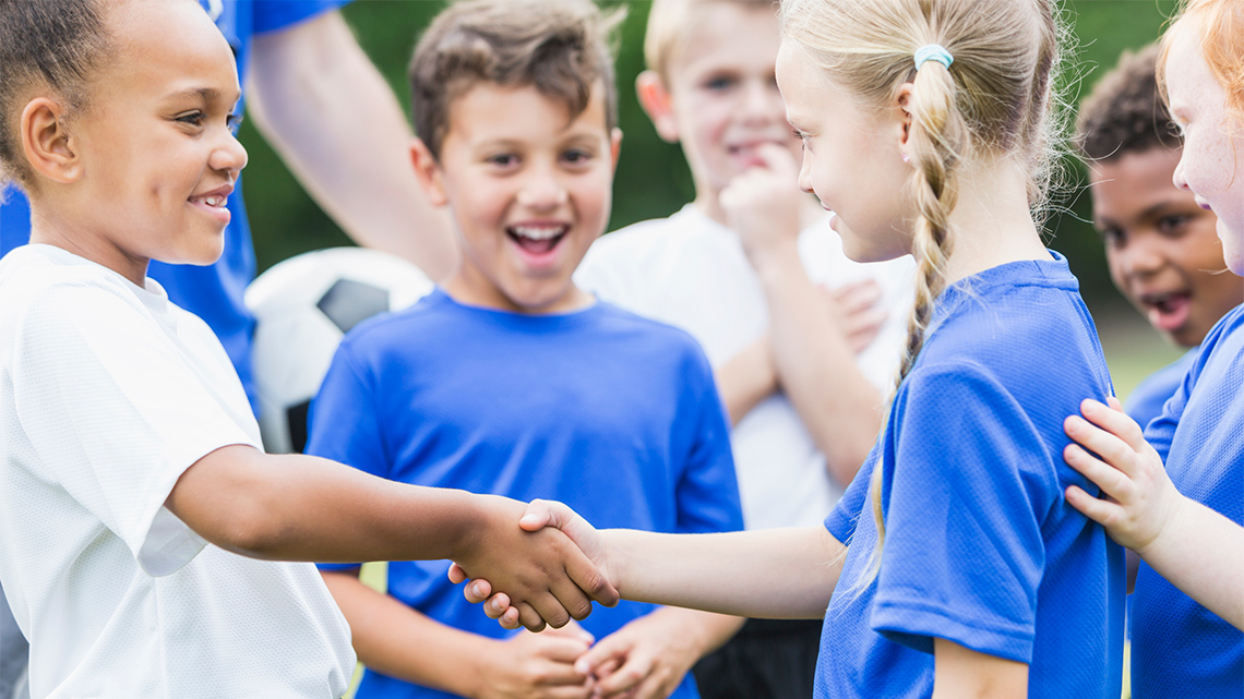 Students from two different teams shake hands.