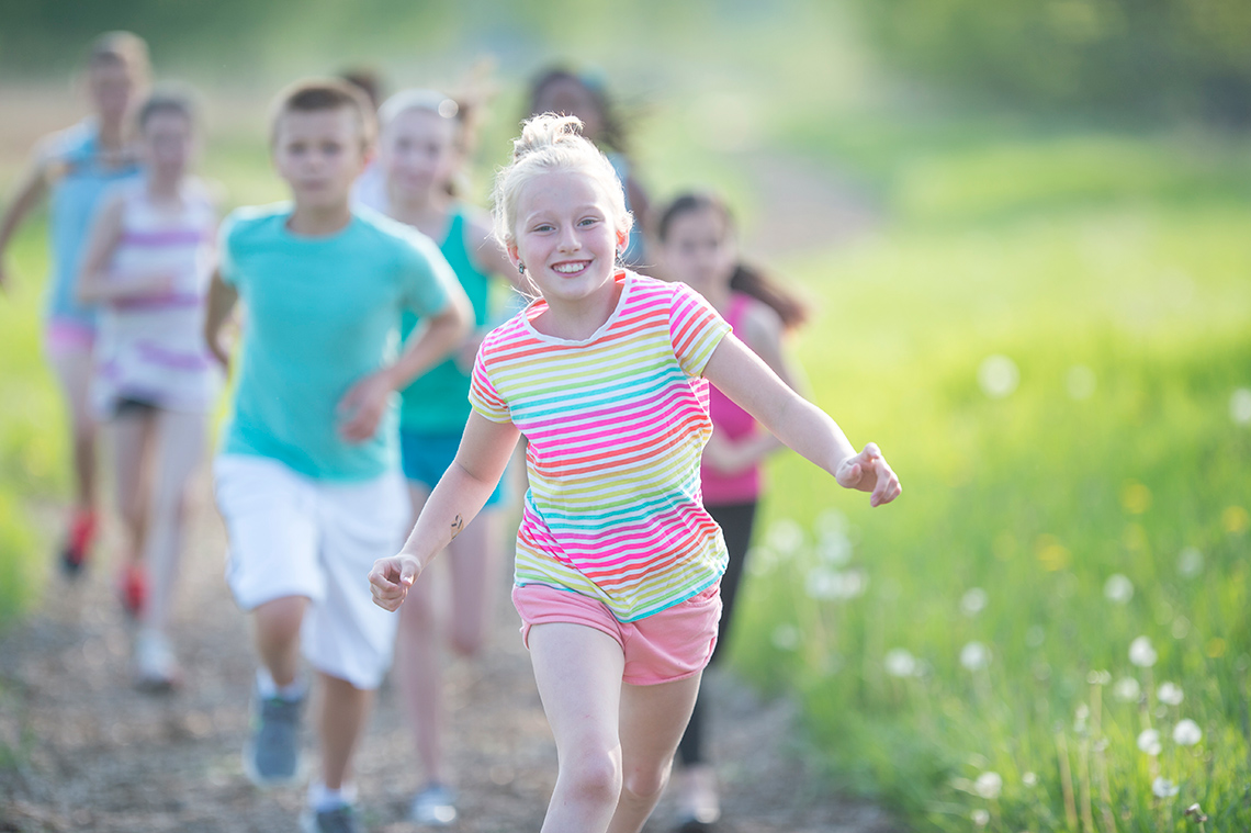 Children running cross country. They are wearing the proper clothing and shoes for running.