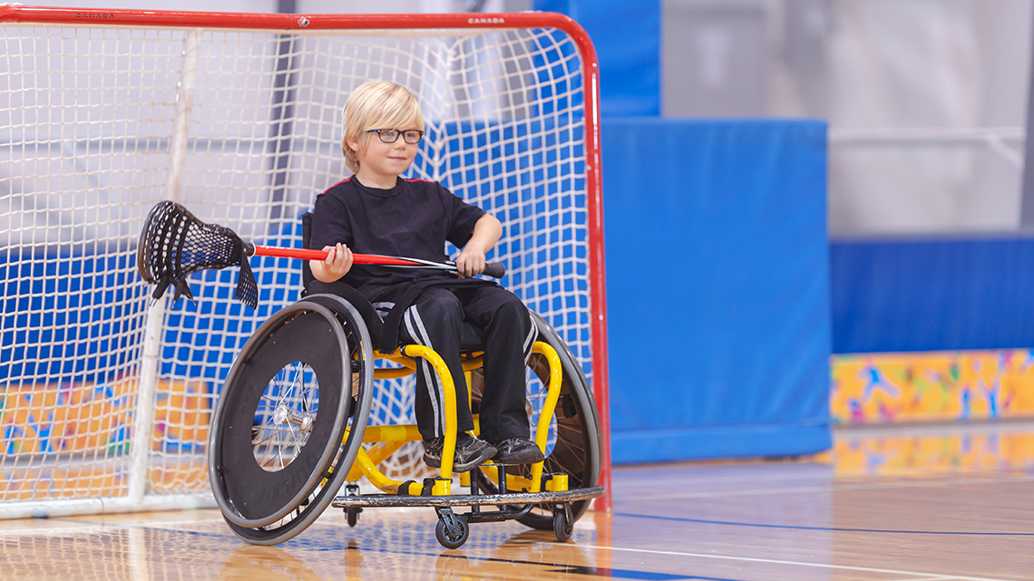 A child who uses a wheelchair plays the position of goalkeeper in lacrosse.