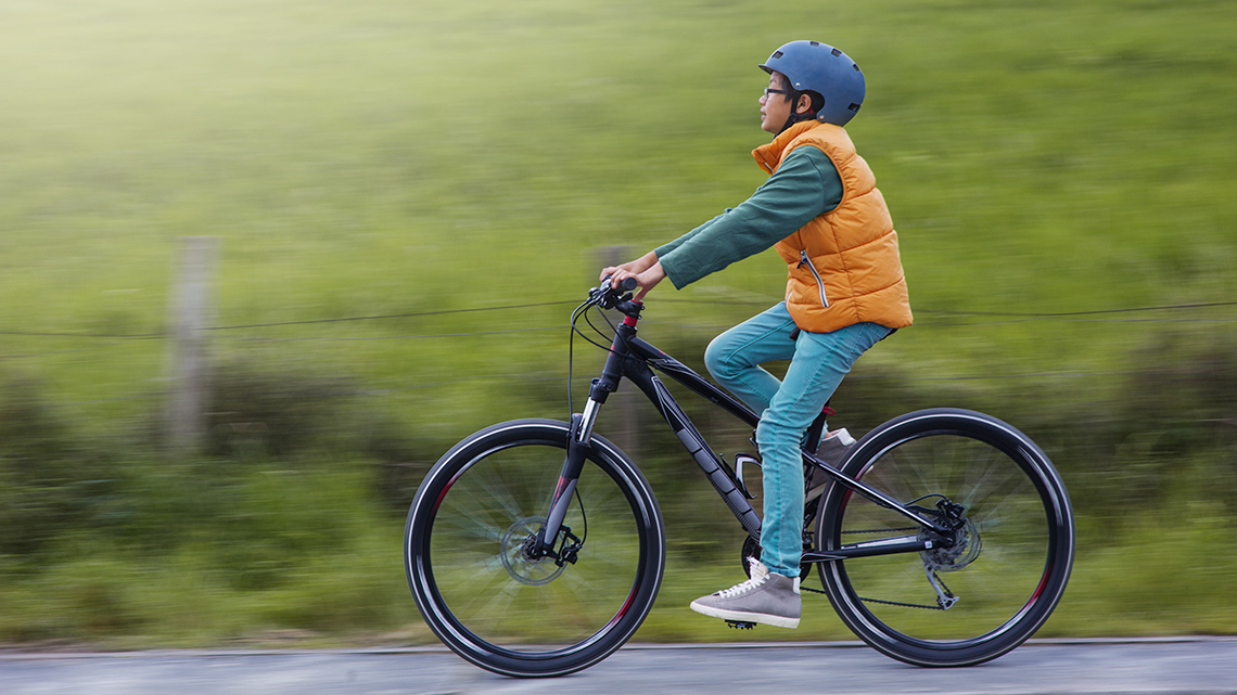 A person wearing a helmet while riding a bicycle.