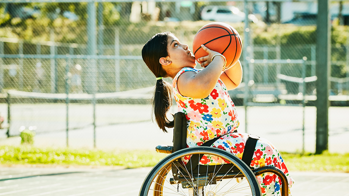 A child who uses a wheelchair playing basketball.