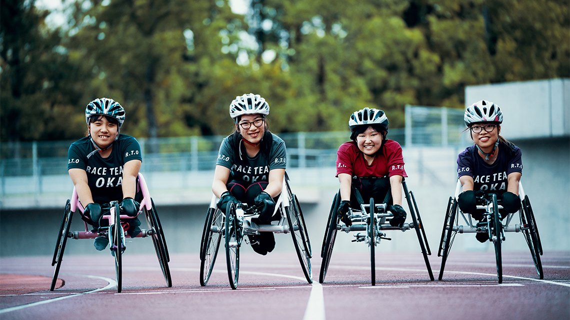 Athletes who use wheelchairs preparing for a race on the track.