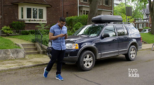 Daniel is walking across the middle of a street while paying attention to his phone.