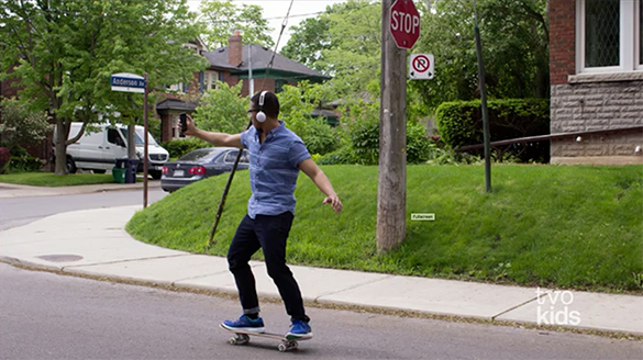 Daniel is skateboarding and wearing headphones.