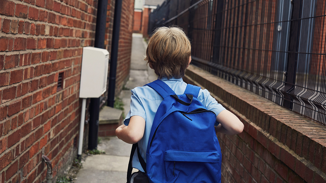 A child walking alone down an alleyway.
