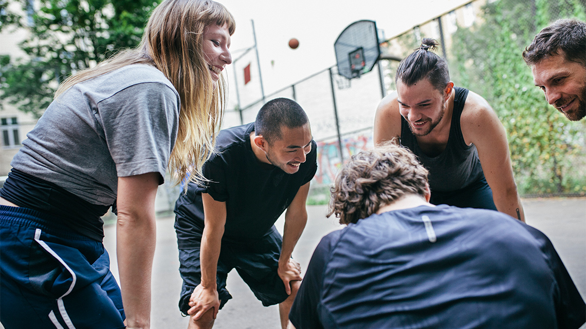 A group of athletes takes a break from playing basketball.