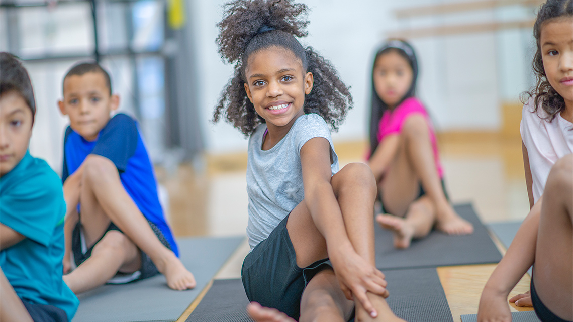 Children stretching on yoga mats.