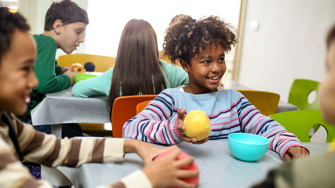 Children eating a healthy snack of fruit.
