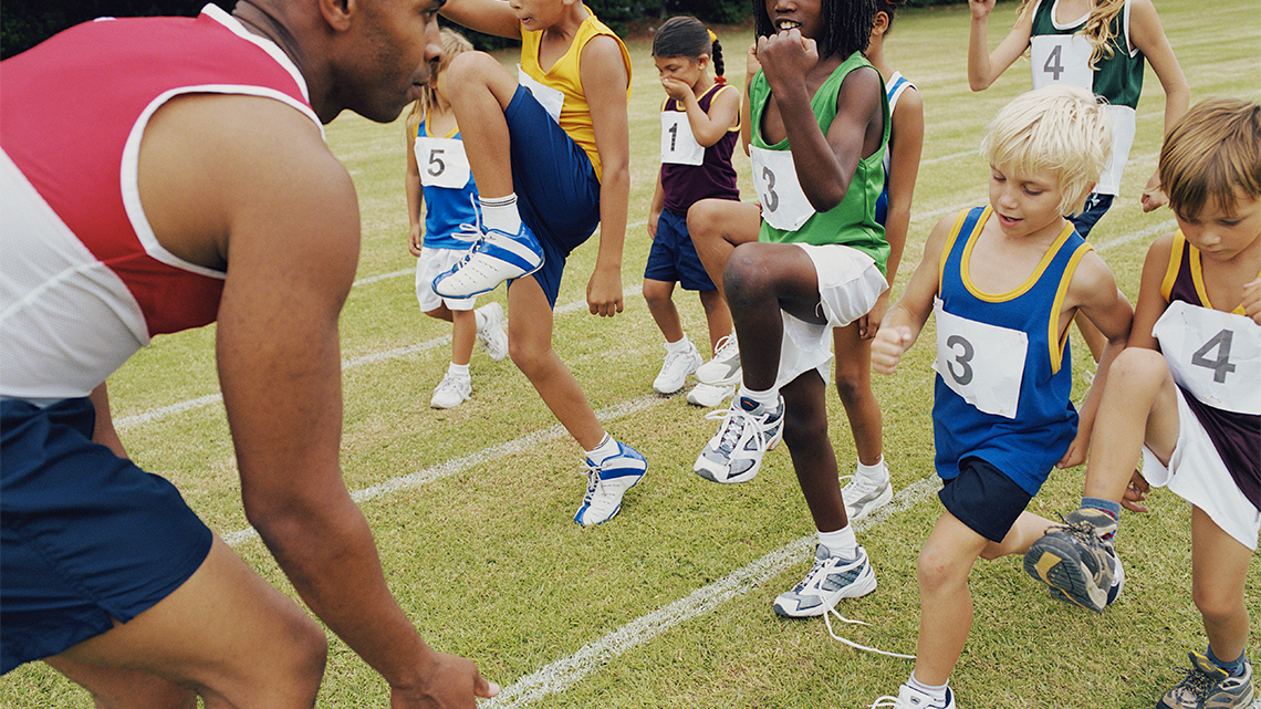 Track runners warming up with high steps.
