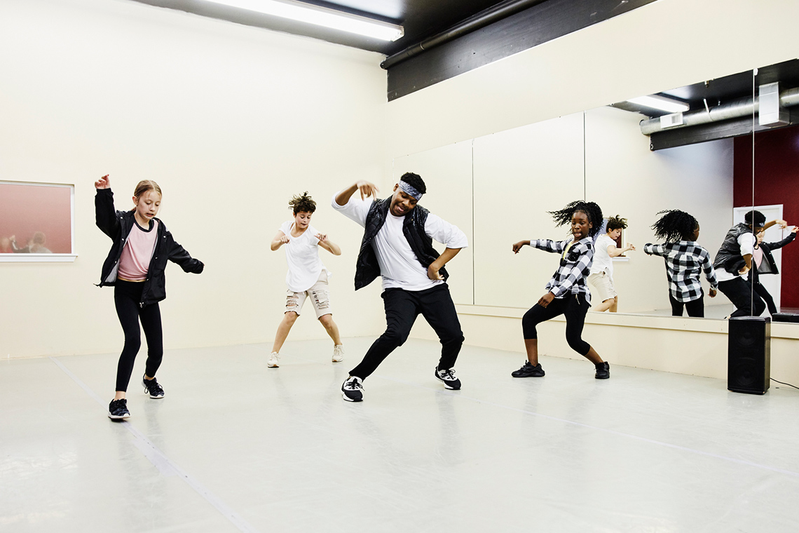 Children dancing in their dance studio at school, while practising their fitness skills.
