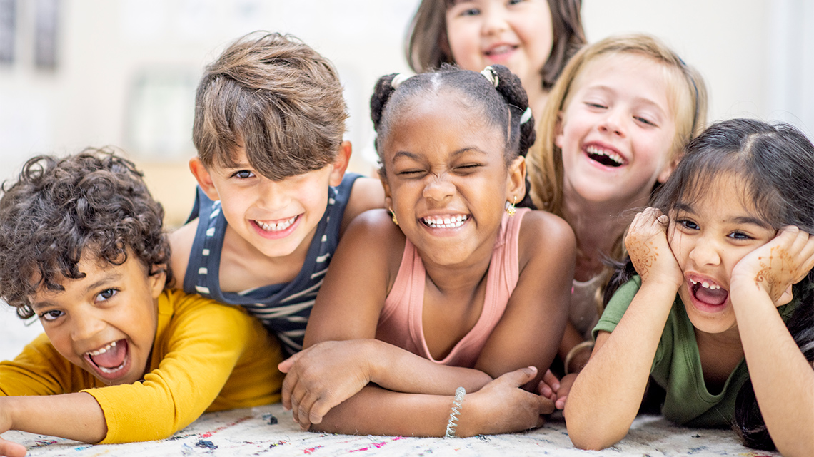 A group of children are making silly faces and laughing