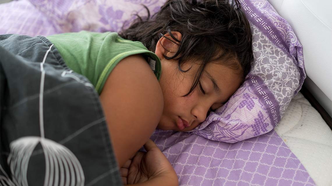 A child sleeping in their bed.