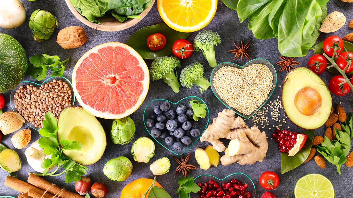 There are several fruits and vegetables in small containers, including blueberries, broccoli, lettuce and oranges.