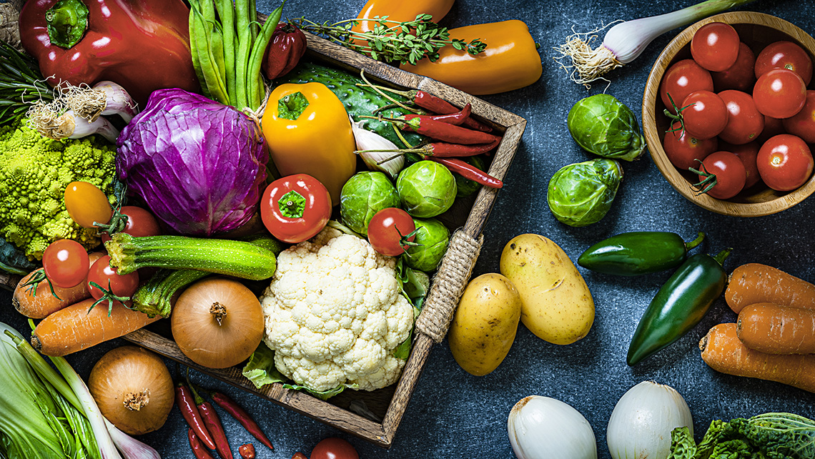 A variety of vegetables, including tomatoes, carrots, broccoli, cucumbers, cauliflower, peppers, and onions.
