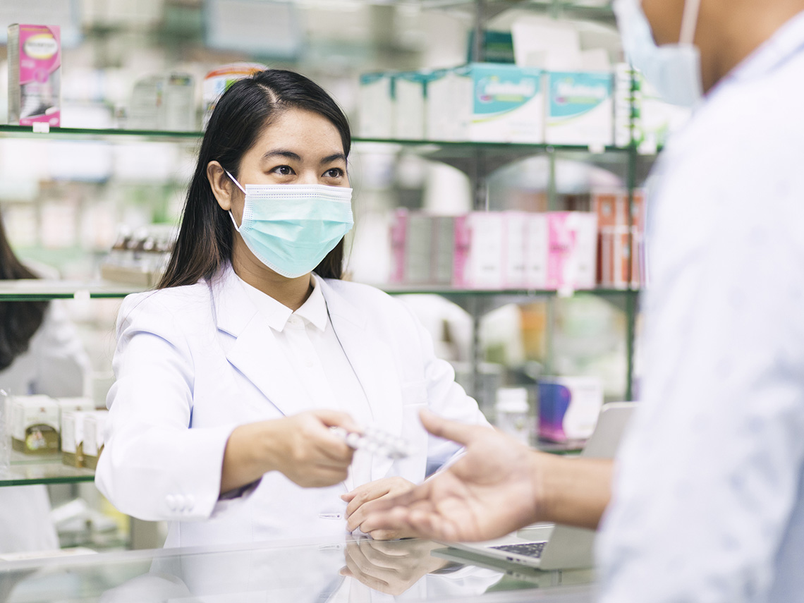 A pharmacist behind the pharmacy counter.