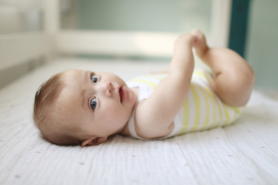 An infant laying in a crib
