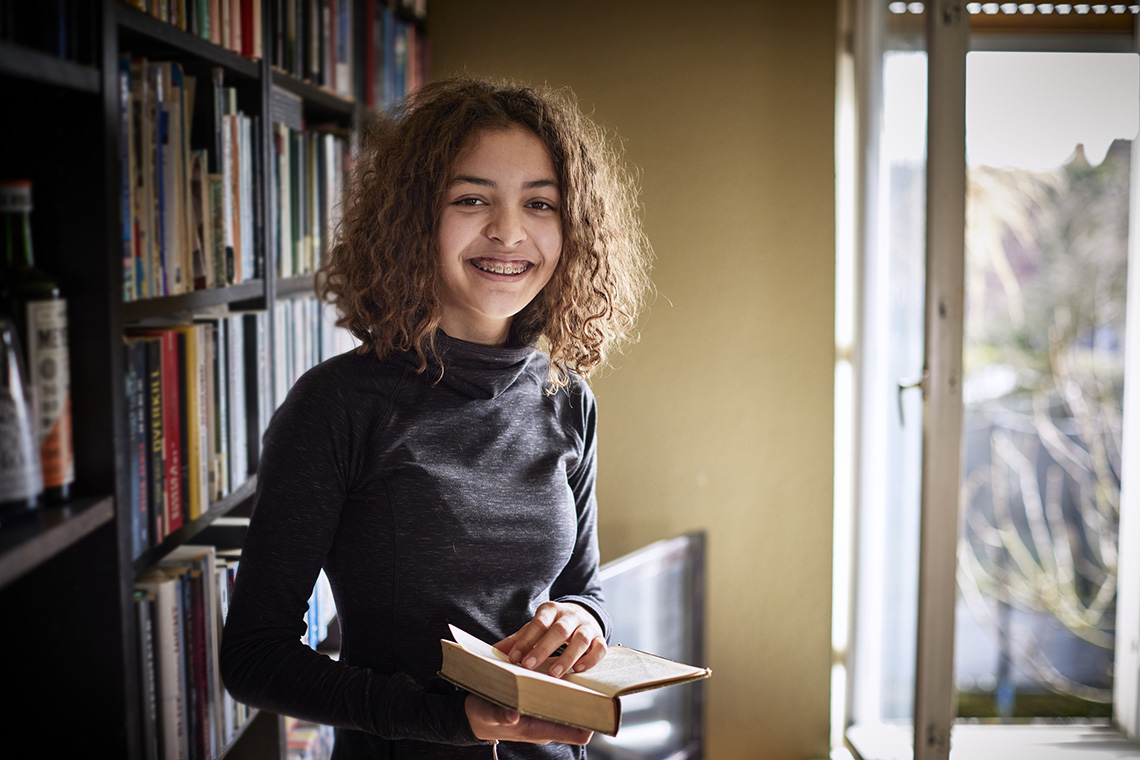 An adolescent smiling.