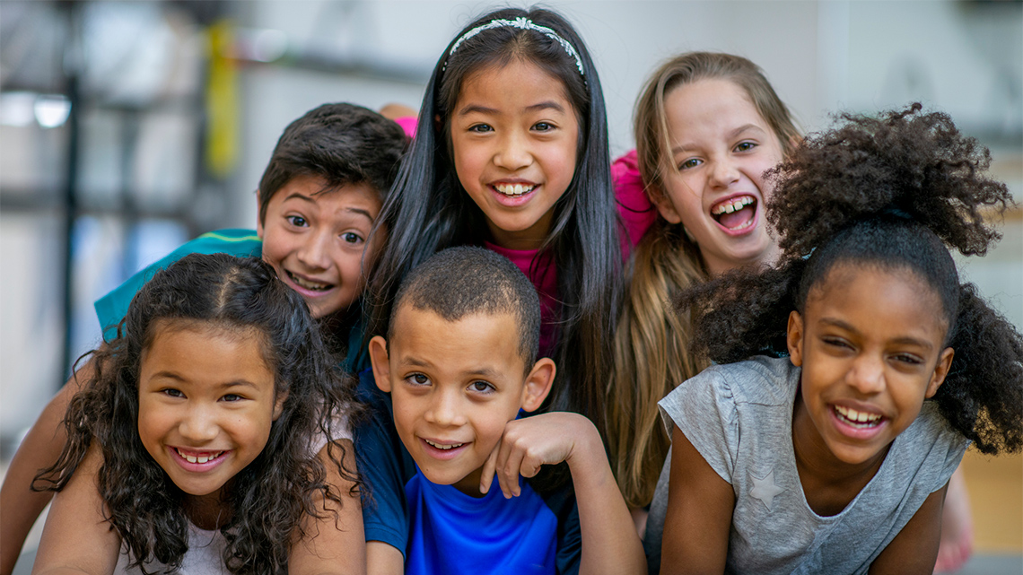 Children of different ethnicities laughing and having fun together.