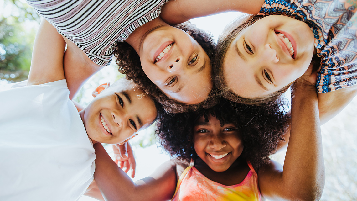 Group of children huddled together in a circle.