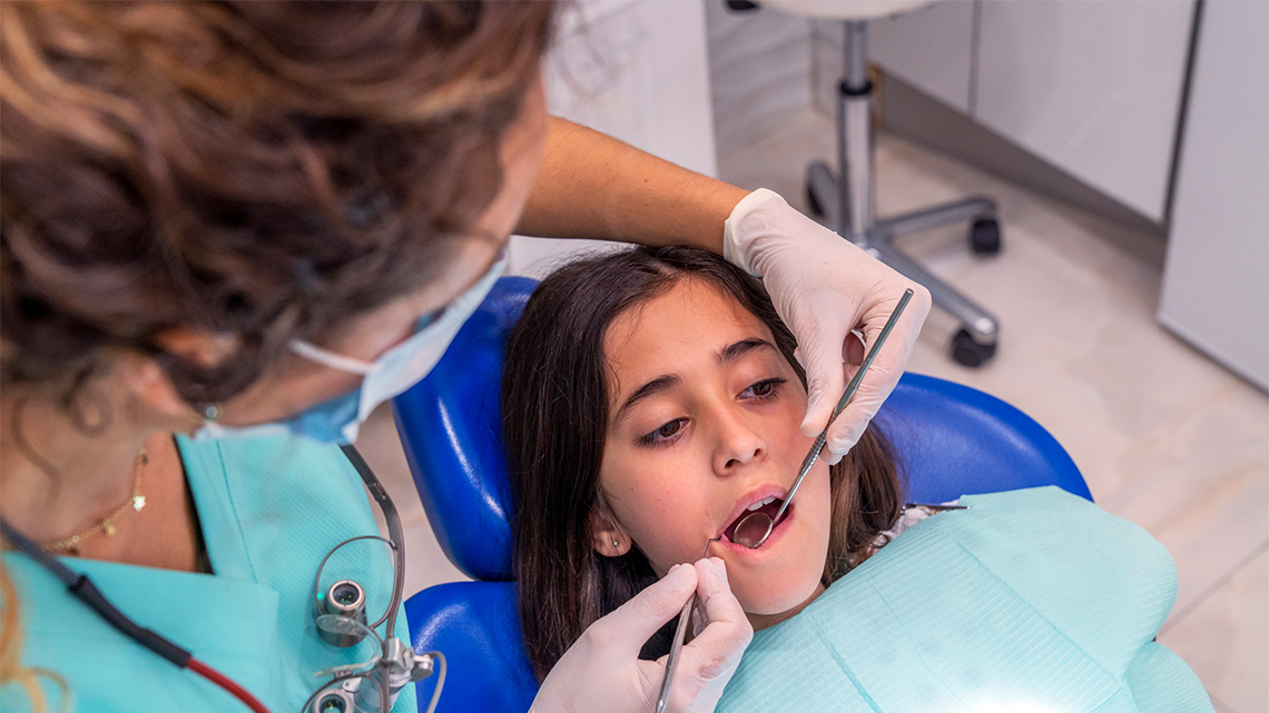 A child getting their teeth cleaned in a dentist's office.
