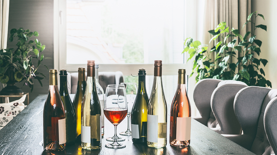 Various bottles and glasses filled with alcohol drinks. 