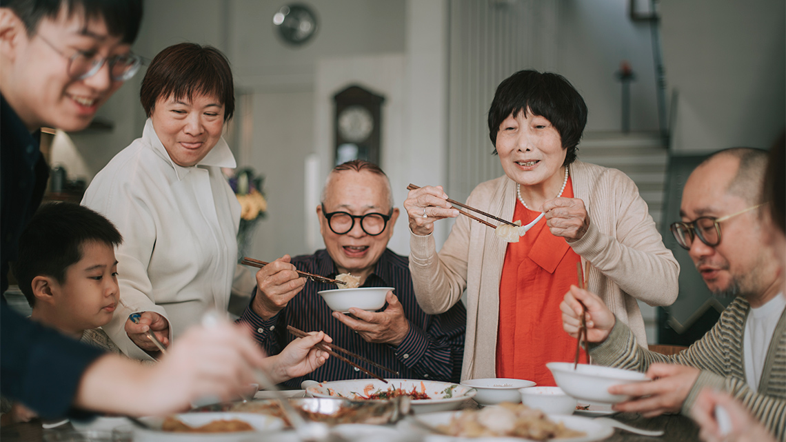A multi-generational family enjoys a meal together.