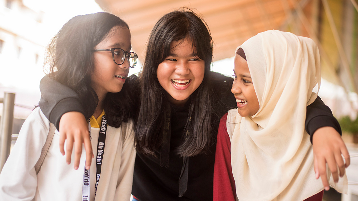 Three friends are smiling and having fun together.