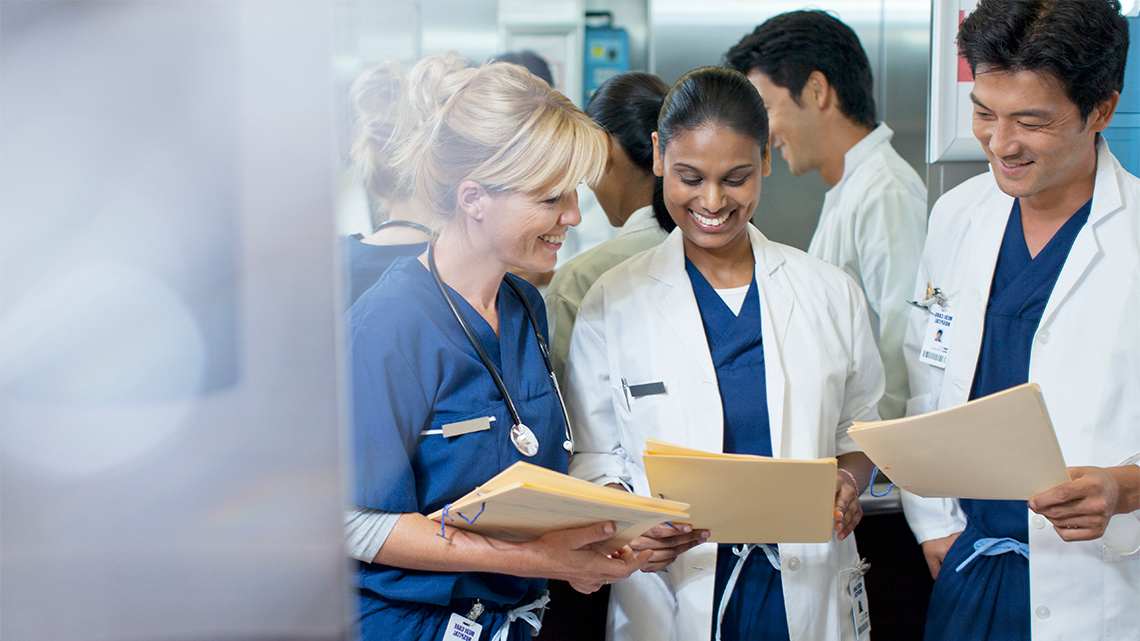 3 medical professionals looking at files.