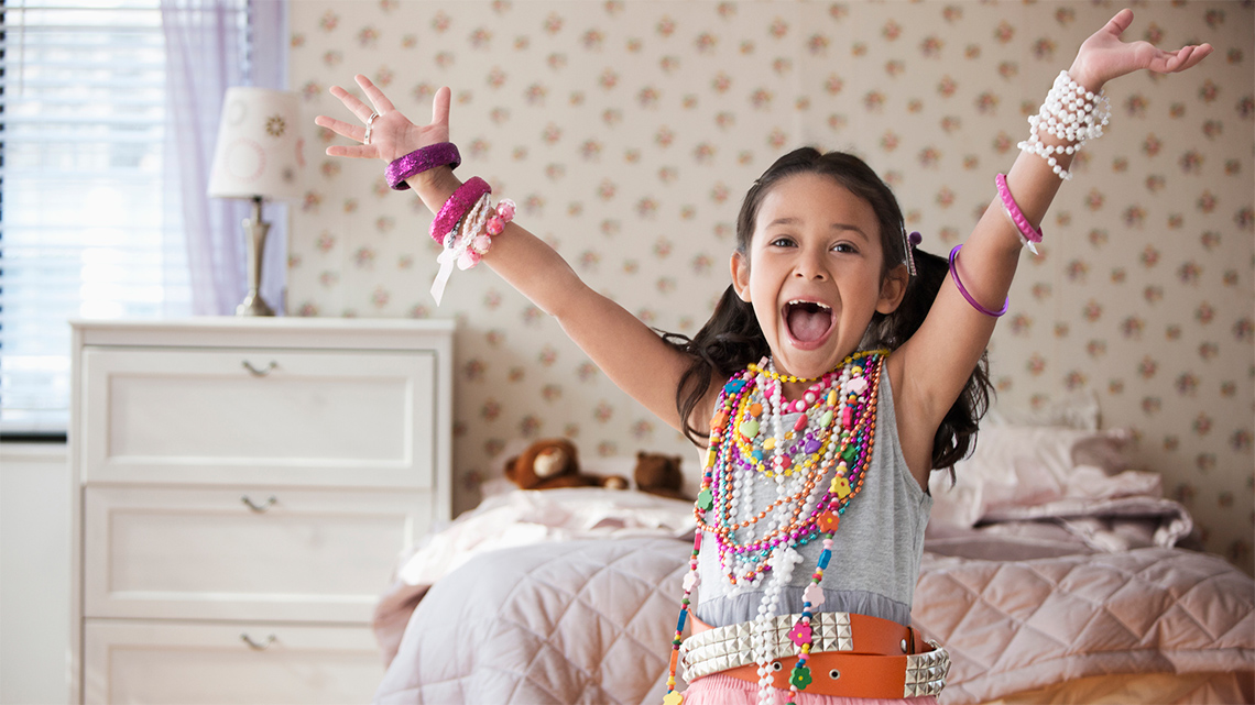 A child with their arms and hands raised up in the air.