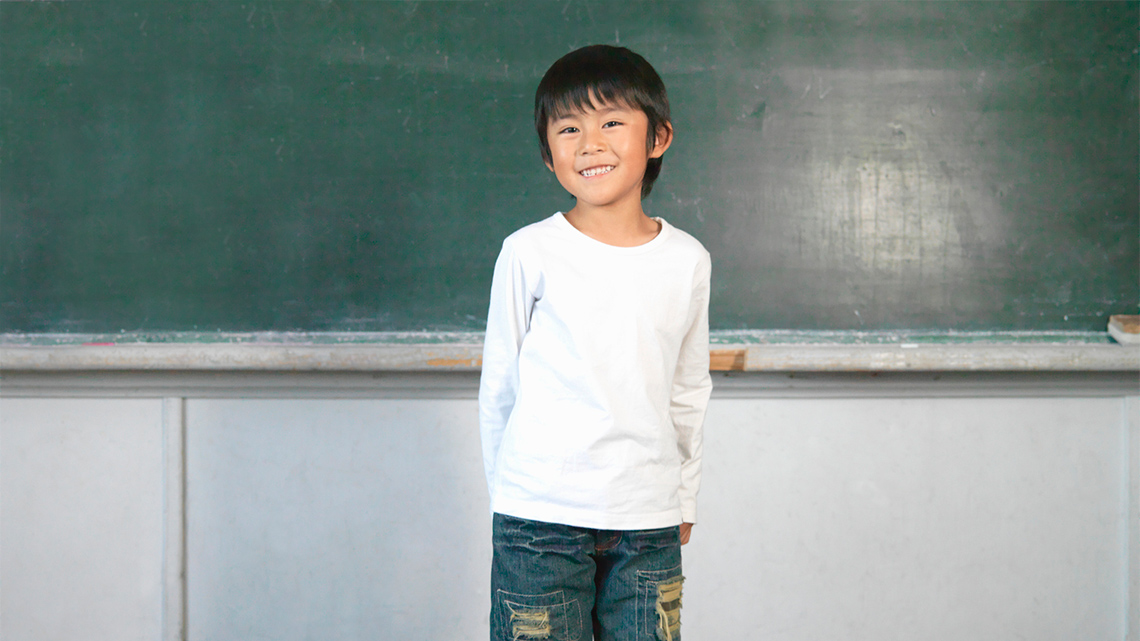 A child with their arms and hands lowered to their waist.