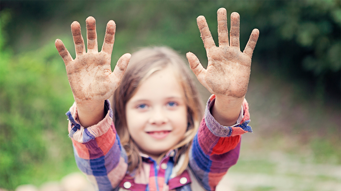 A child showing their hands, with palms facing out.