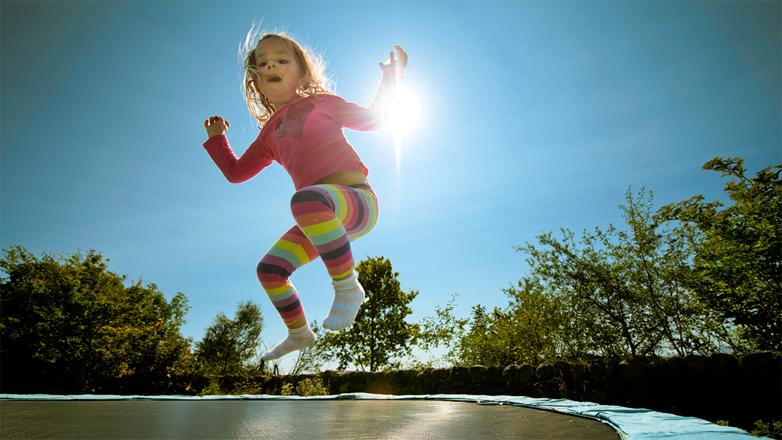 A child is jumping on a trampoline.