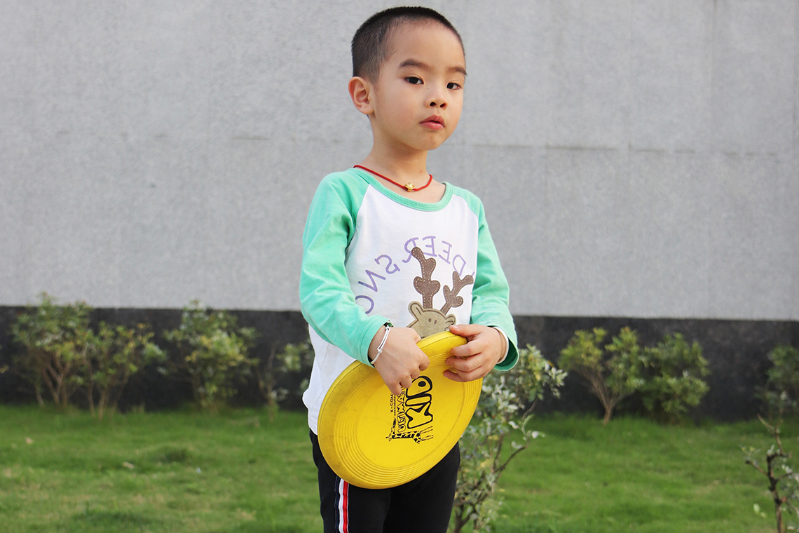 A child holding a frisbee with both hands.