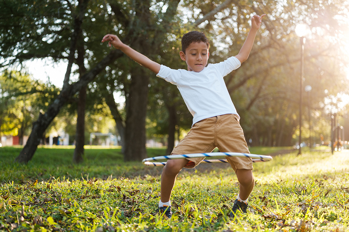 A child is playing with the hula hoop.
