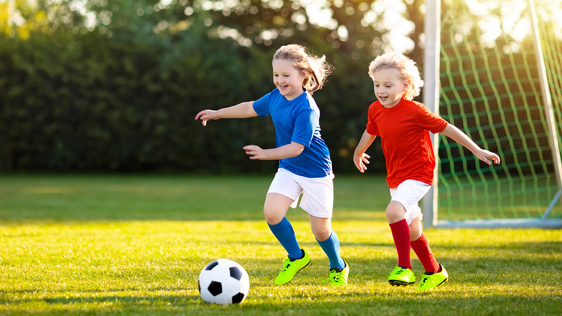 Two soccer players are trying to receive the ball.