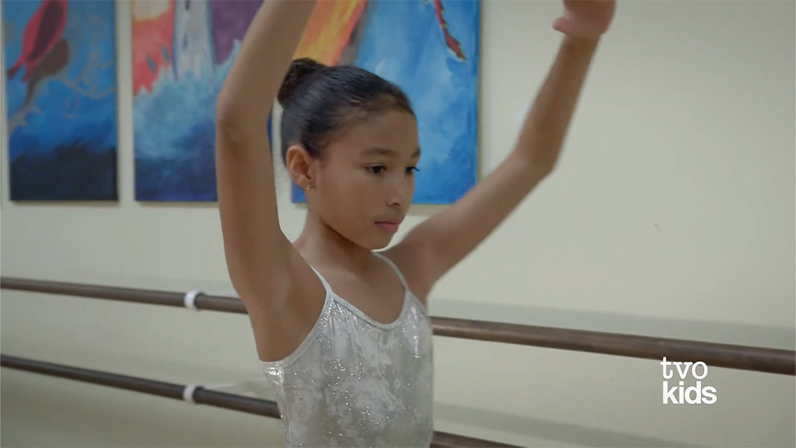 One girl extending her arms, and curving them over her head.