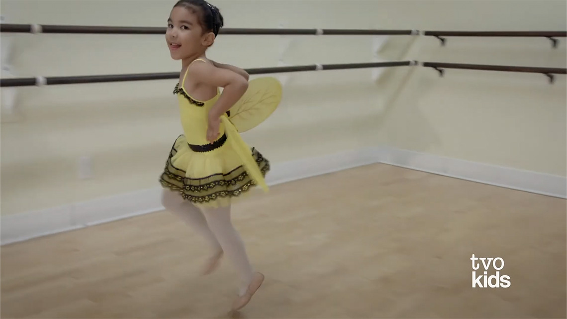 One girl moving across the floor in a skipping motion.