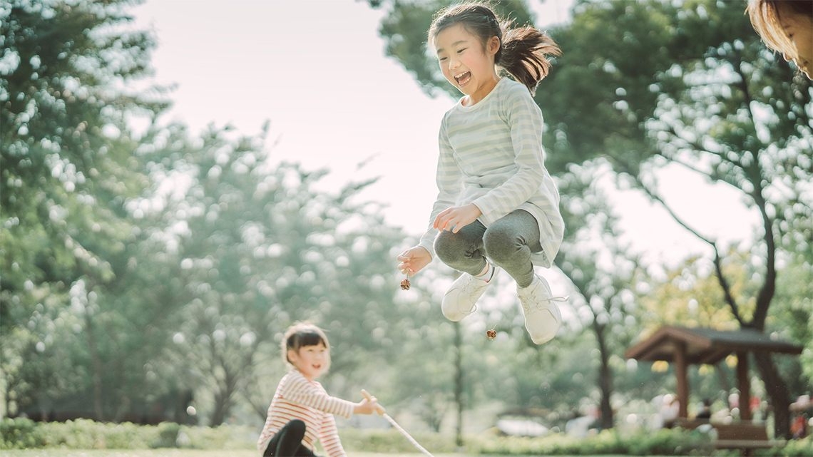 A child jumping across a skipping rope.