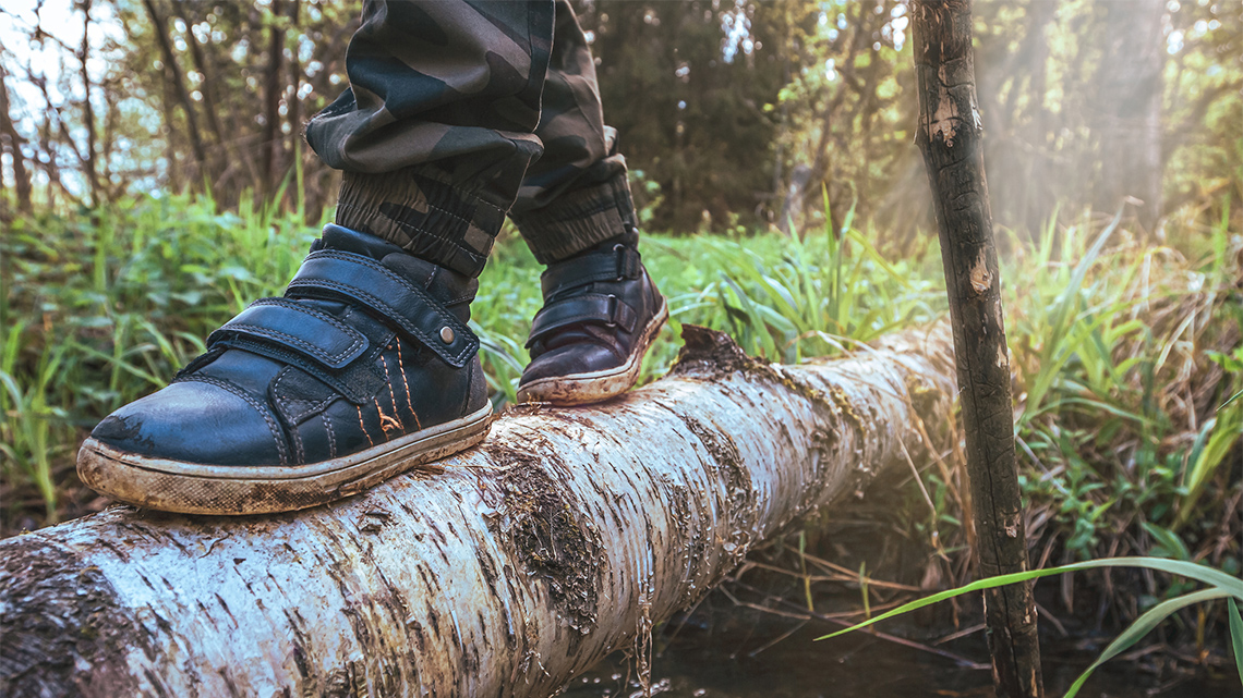 A child stepping along a log.