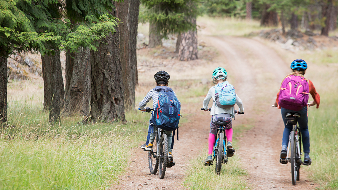 Children balancing while riding their bikes.