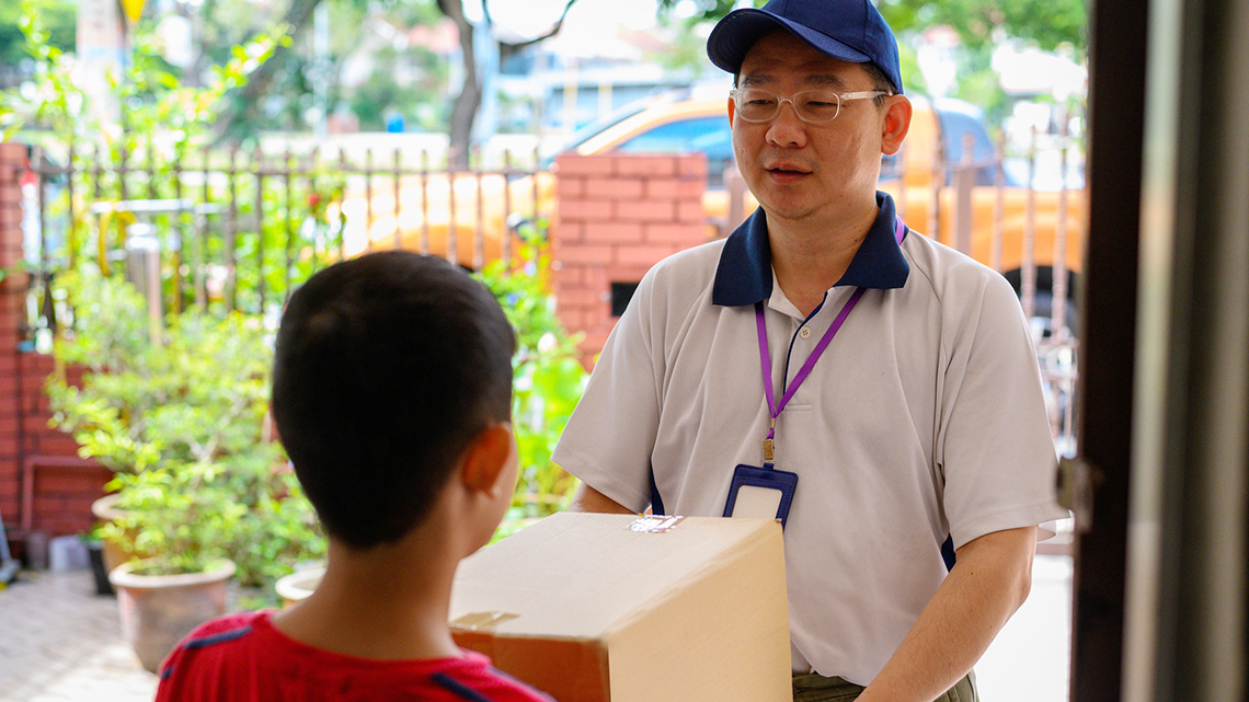 A person hands another person a package.