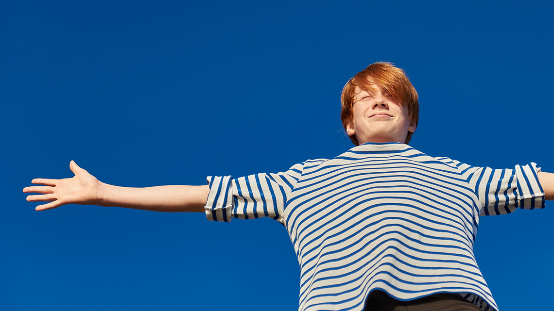 A person extends their arms out to the side with their hands outstretched.